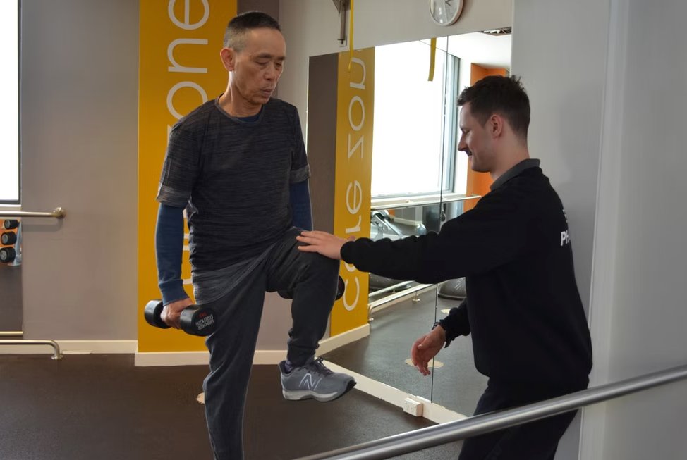 Exercise Physiologist guiding client through resistance band exercise